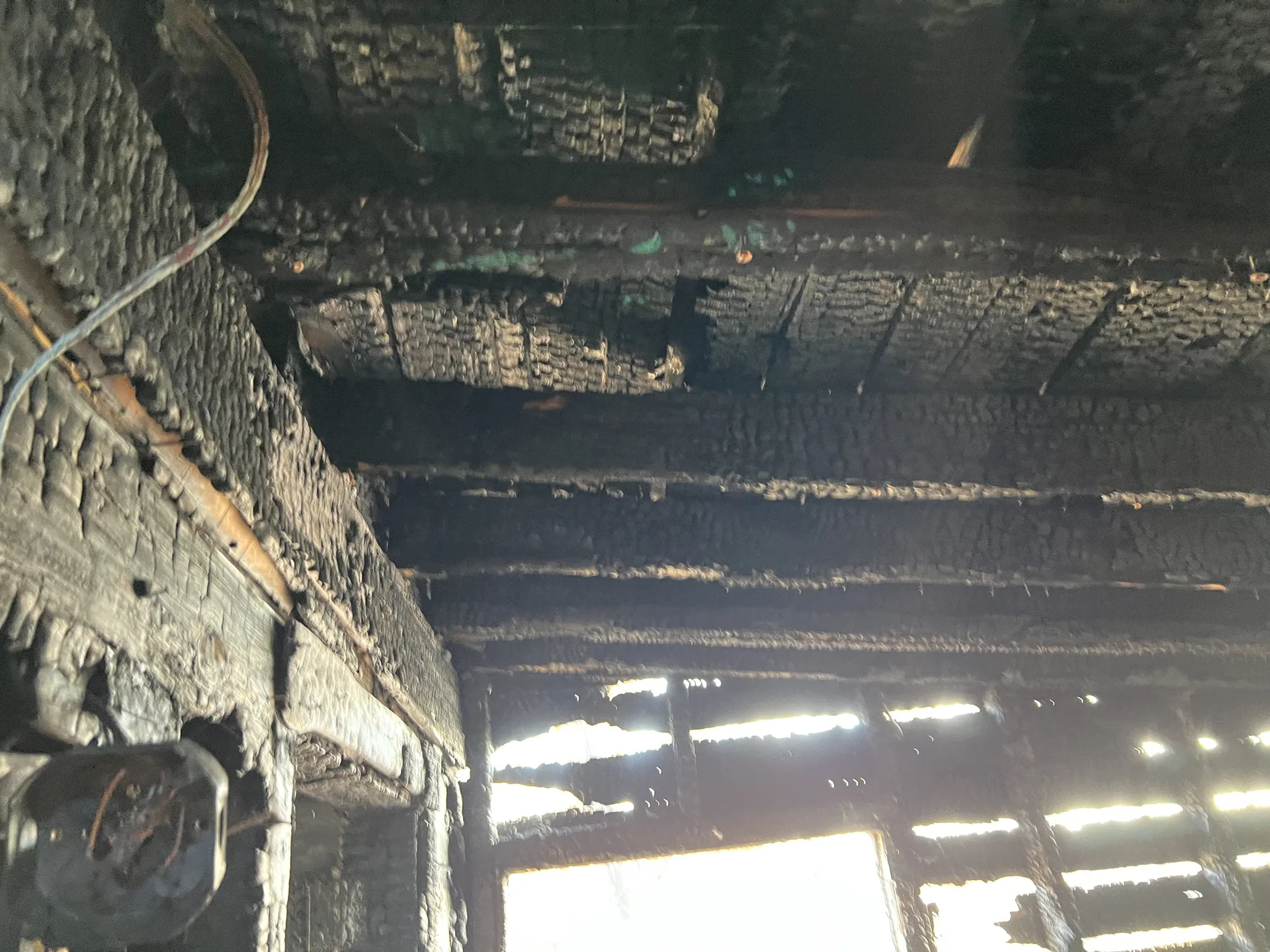 Wall showing both char and soot zones from house fire in Grand Rapids MI illustrating the difference between cleaned and demoed materials in fire restoration